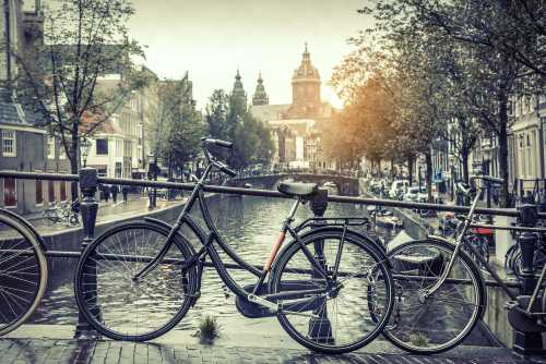 Gruppenausflug und Gruppenticket in Amsterdam: geparkte Fahrräder auf einer Brücke in Amsterdam - Blick auf einer der Grachten (Shutterstock)
